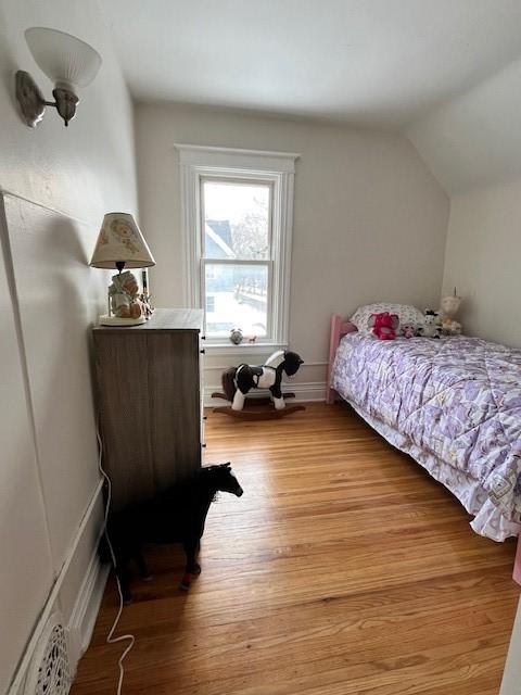 bedroom featuring lofted ceiling and light wood-type flooring