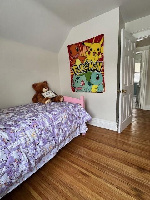 bedroom featuring vaulted ceiling and wood-type flooring