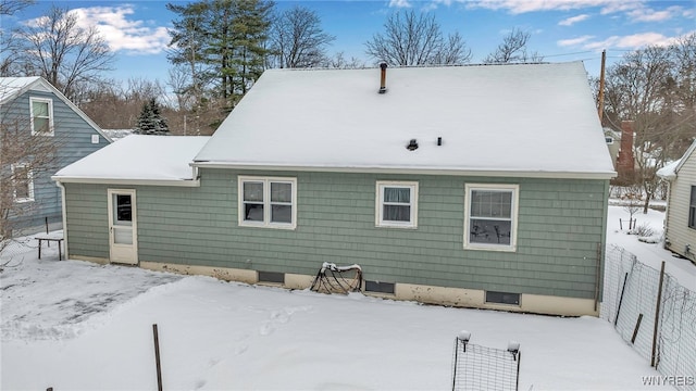 view of snow covered back of property