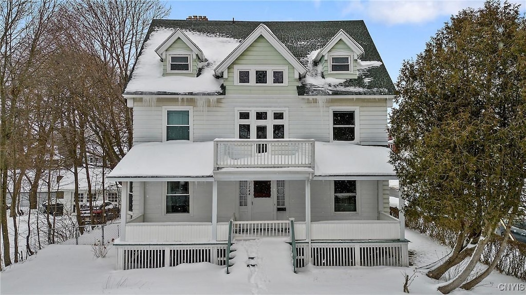 cape cod-style house featuring a porch and a balcony