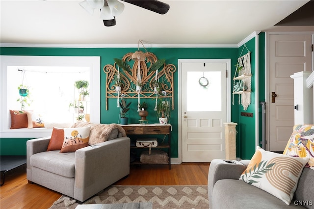 sitting room with wood-type flooring, ceiling fan, and crown molding