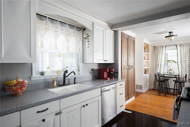 kitchen featuring sink, white cabinetry, ornamental molding, dark hardwood / wood-style flooring, and dishwasher