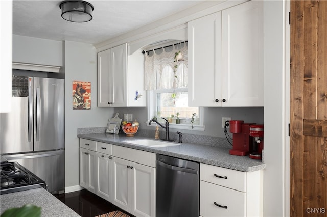 kitchen with stainless steel appliances, sink, and white cabinets