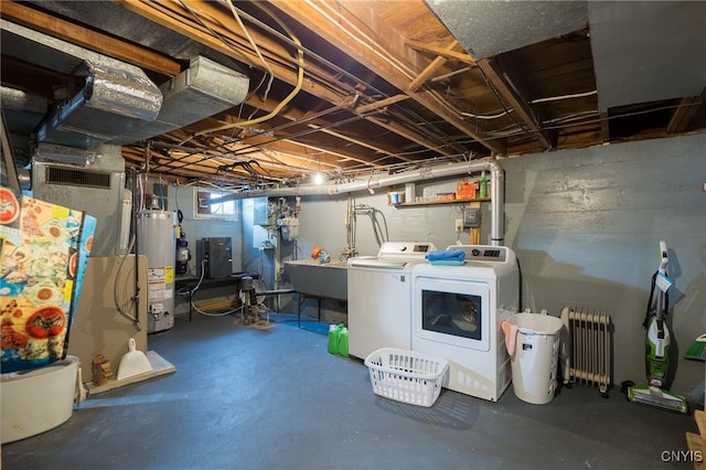 basement featuring radiator, washer and clothes dryer, sink, and water heater