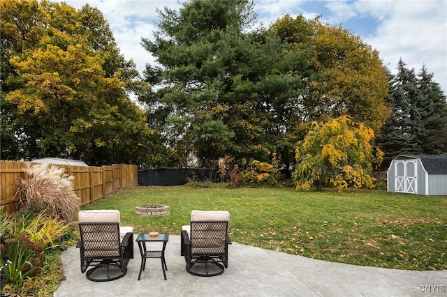 view of yard featuring a patio, a storage unit, and a fire pit