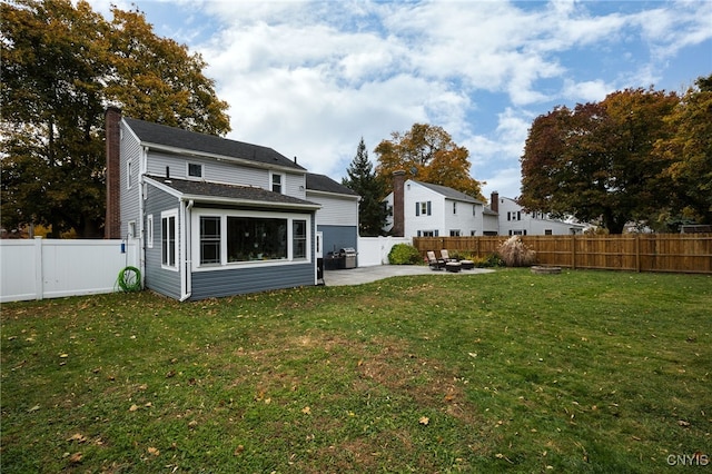 rear view of property featuring a patio area and a lawn