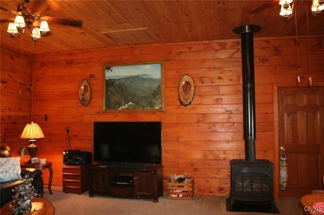 living room featuring a wood stove, light colored carpet, wood ceiling, and ceiling fan