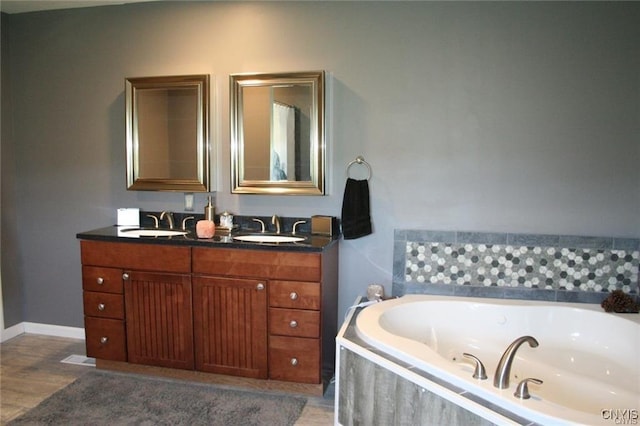 bathroom featuring vanity, hardwood / wood-style floors, and a relaxing tiled tub