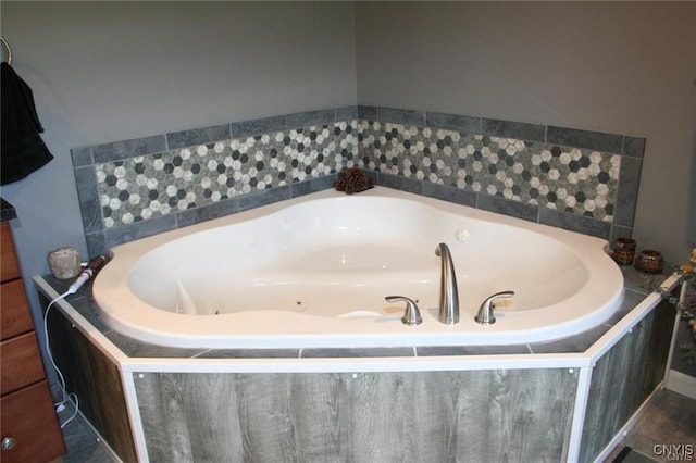 bathroom with tile patterned flooring and a relaxing tiled tub