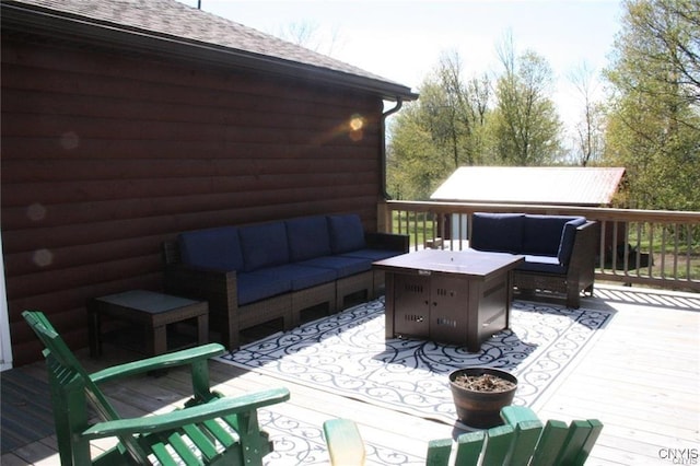 wooden deck featuring an outdoor living space with a fire pit