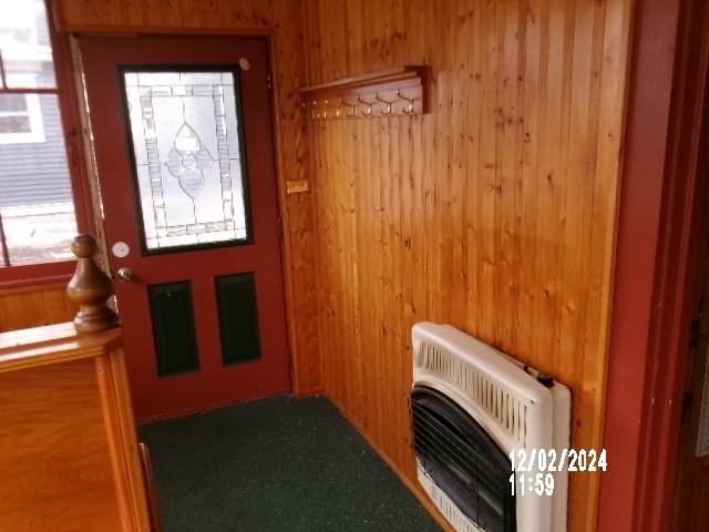 entrance foyer with wooden walls and heating unit