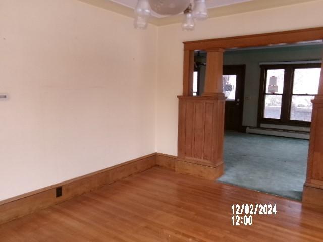 spare room with wood-type flooring and baseboard heating