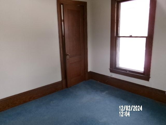 carpeted spare room featuring plenty of natural light