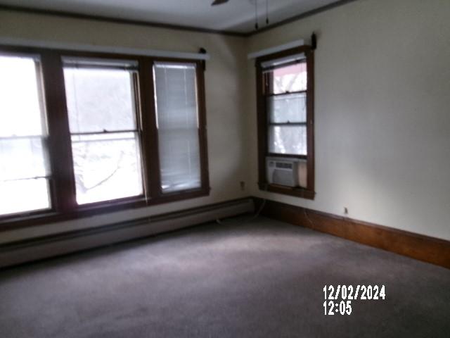 unfurnished room featuring cooling unit, ceiling fan, carpet floors, and a baseboard heating unit