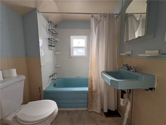 full bathroom featuring shower / tub combo with curtain, toilet, sink, vaulted ceiling, and tile walls