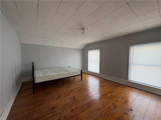 unfurnished bedroom with wood-type flooring and vaulted ceiling