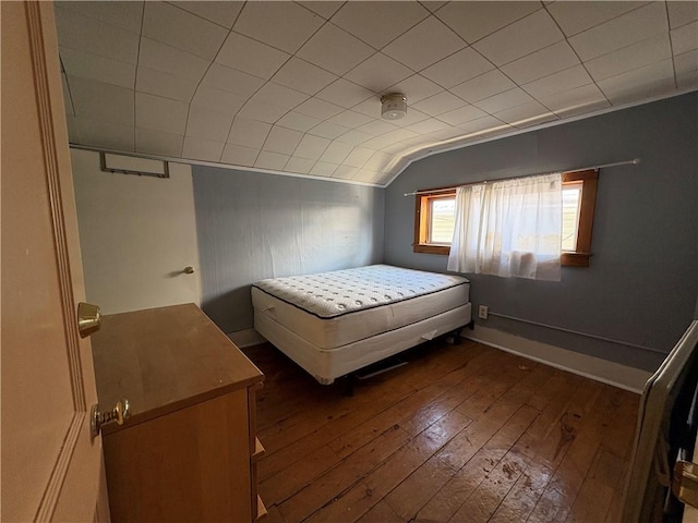 unfurnished bedroom with dark wood-type flooring and lofted ceiling