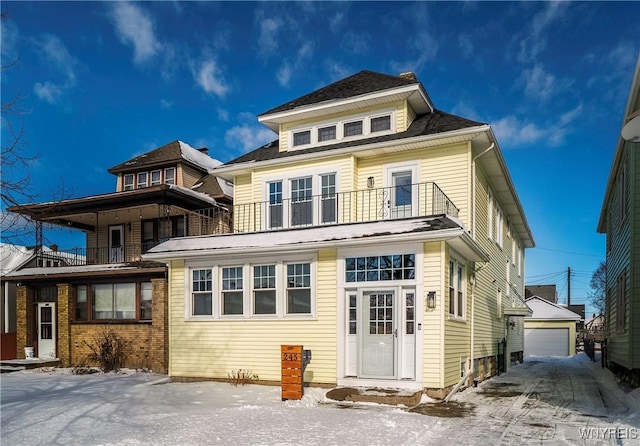 rear view of property with an outbuilding, a garage, and a balcony