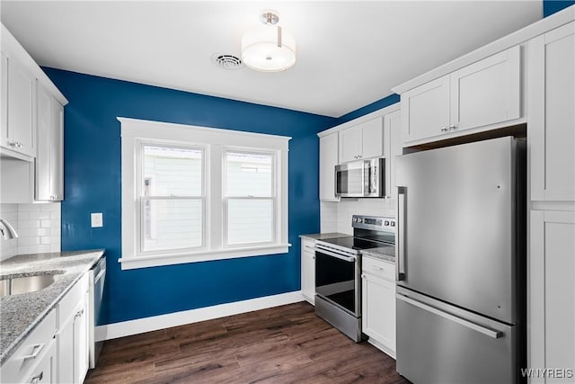 kitchen featuring stainless steel appliances, tasteful backsplash, sink, and white cabinetry