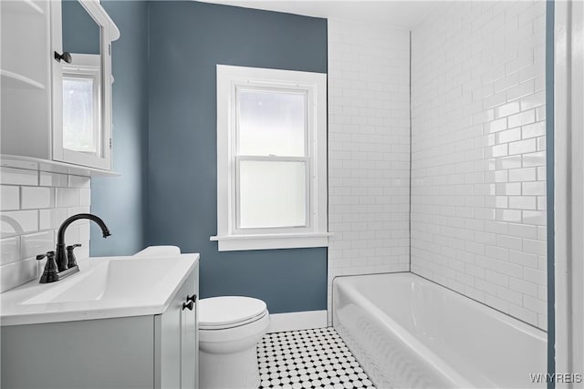 full bathroom featuring vanity, backsplash, tiled shower / bath, and toilet