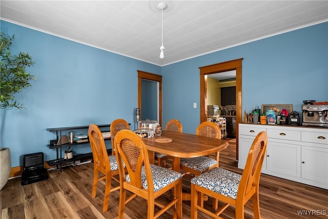 dining space with crown molding and dark hardwood / wood-style floors