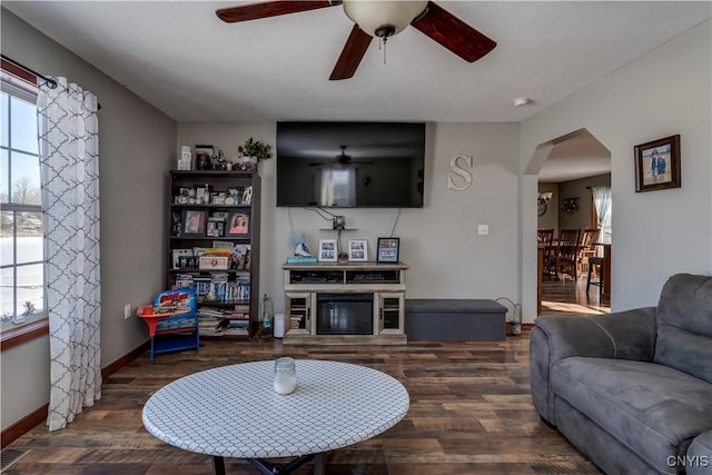 living room featuring a fireplace, a wealth of natural light, dark hardwood / wood-style floors, and ceiling fan