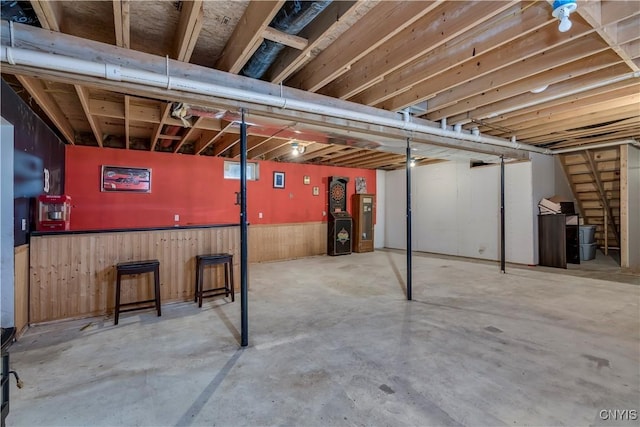 basement featuring wood walls