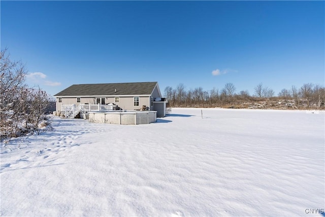 view of snow covered rear of property