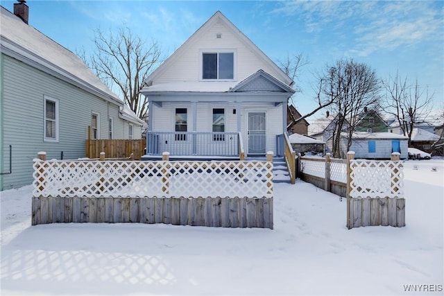 snow covered house featuring a porch