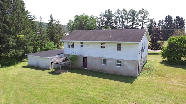 rear view of house featuring a yard