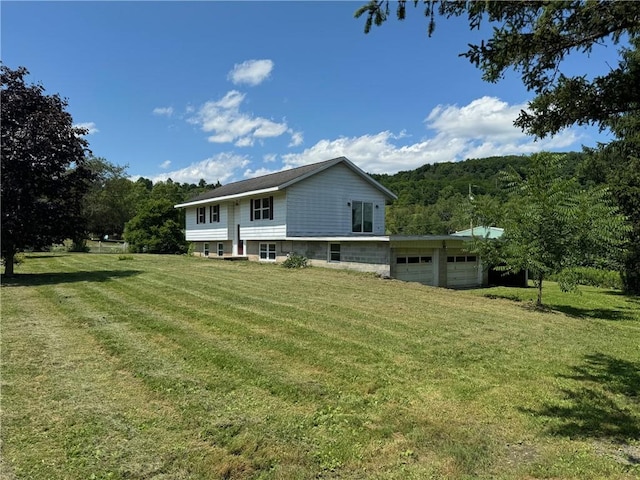 rear view of house featuring a garage and a lawn