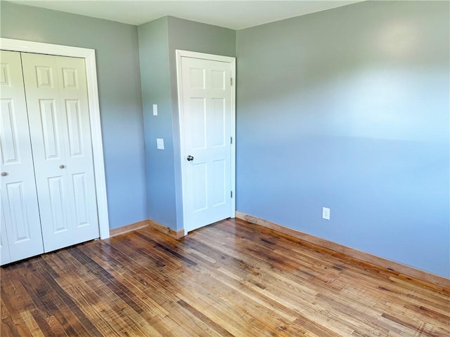 unfurnished bedroom with hardwood / wood-style flooring and a closet