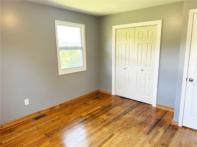 unfurnished bedroom with wood-type flooring and a closet