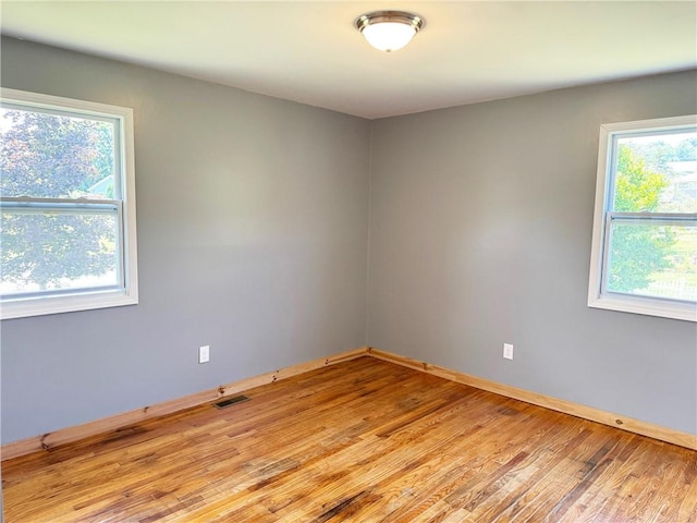 unfurnished room featuring a healthy amount of sunlight and light hardwood / wood-style floors