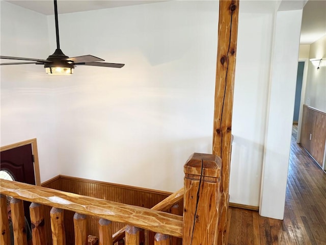 stairs featuring hardwood / wood-style floors, ceiling fan, and wood walls