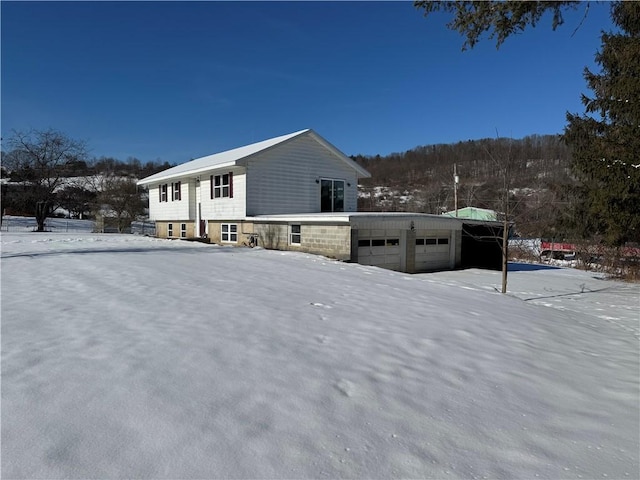 snow covered property with a garage