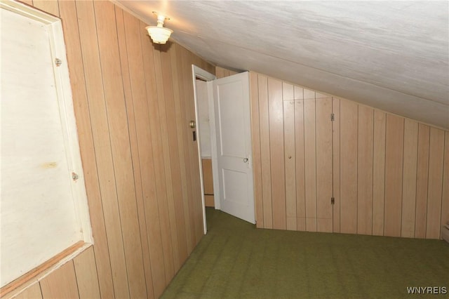 bonus room featuring lofted ceiling and wooden walls