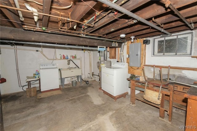 basement featuring electric panel, separate washer and dryer, and sink