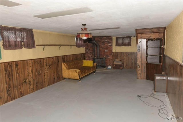 basement with a wood stove and wood walls