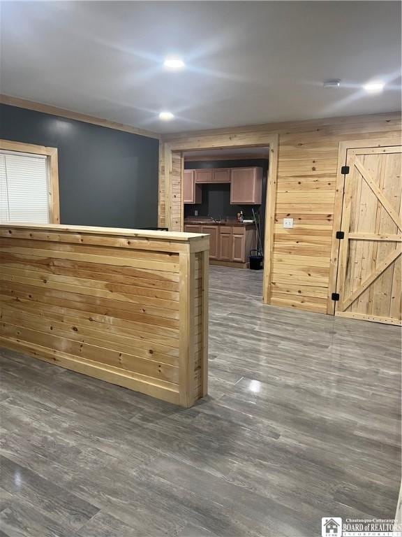 bar with dark wood-type flooring and wood walls