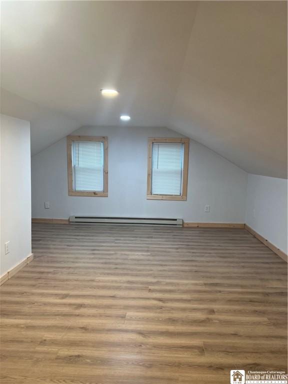 bonus room featuring baseboard heating, vaulted ceiling, and light wood-type flooring