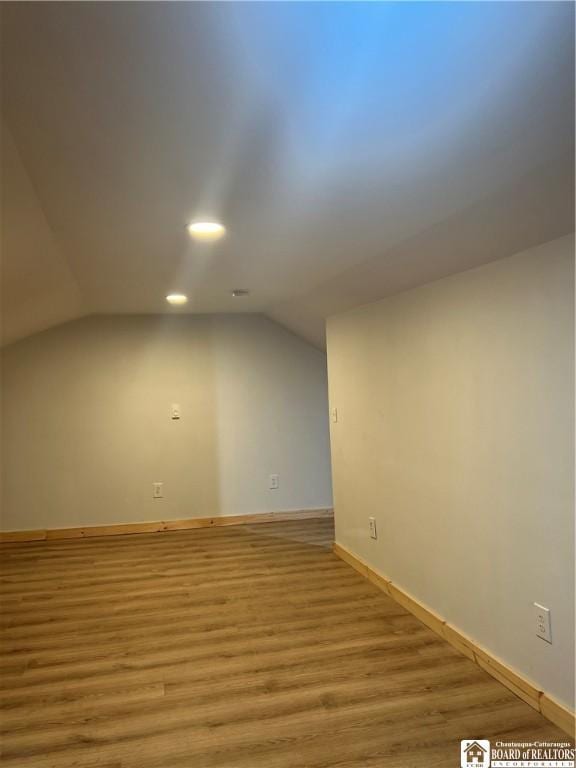 bonus room with light hardwood / wood-style flooring and vaulted ceiling