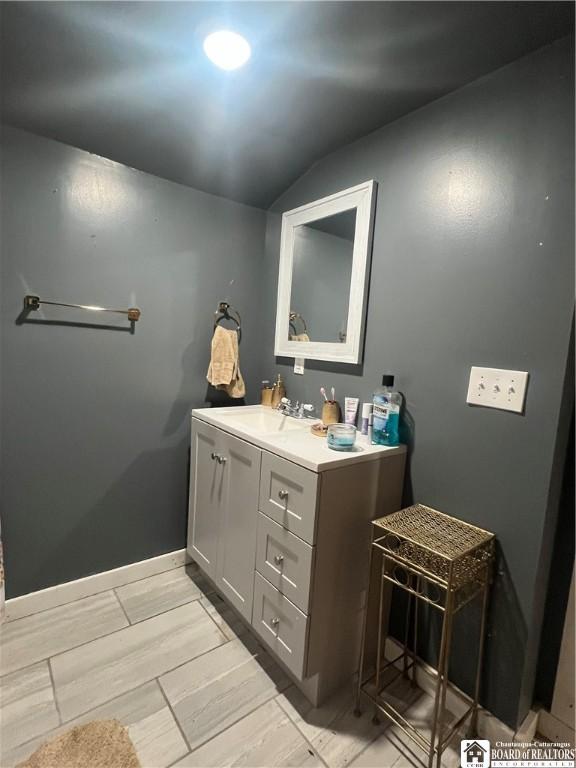 bathroom featuring lofted ceiling and vanity