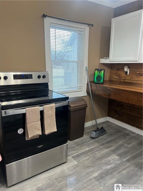 kitchen featuring white cabinetry, stainless steel electric stove, and light wood-type flooring