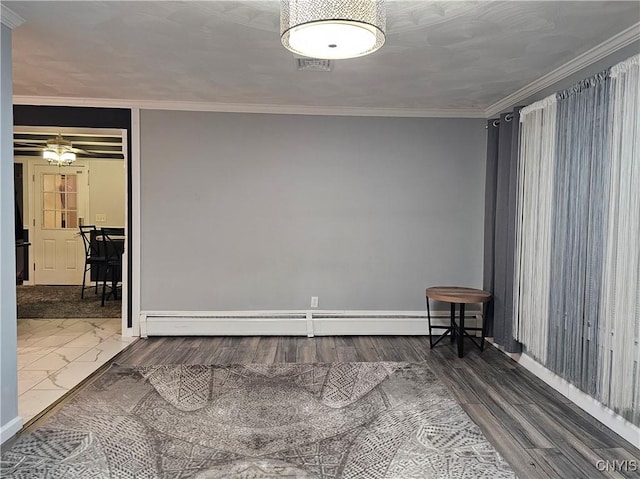 spare room featuring crown molding and baseboard heating