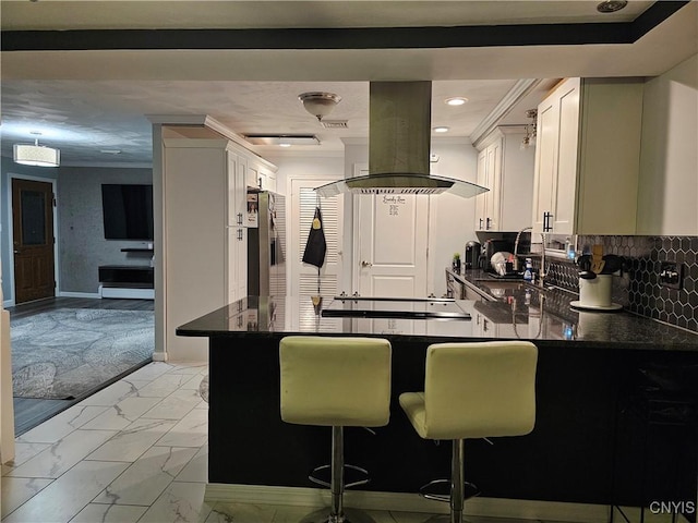 kitchen with white cabinetry, a kitchen breakfast bar, island exhaust hood, kitchen peninsula, and stainless steel refrigerator with ice dispenser