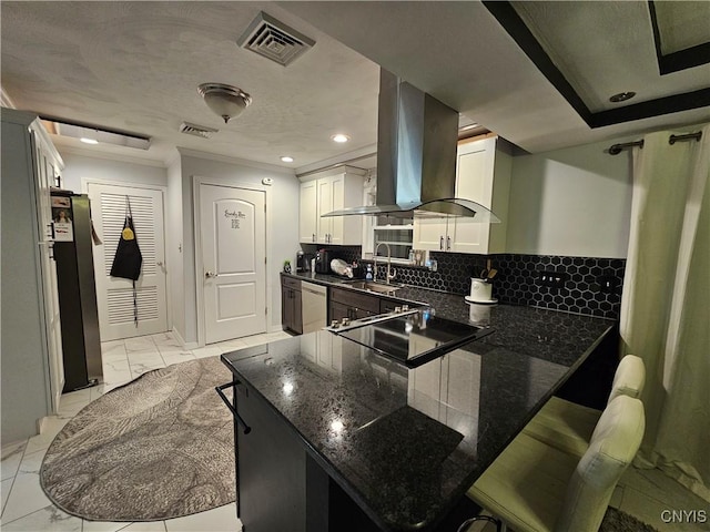 kitchen featuring white cabinetry, appliances with stainless steel finishes, island range hood, and kitchen peninsula