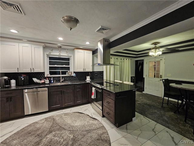 kitchen featuring appliances with stainless steel finishes, white cabinetry, sink, island exhaust hood, and crown molding