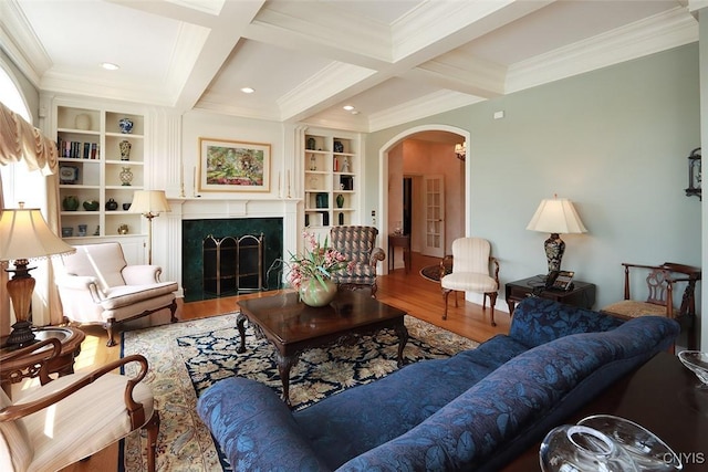 living room with hardwood / wood-style flooring, built in features, coffered ceiling, a fireplace, and beamed ceiling