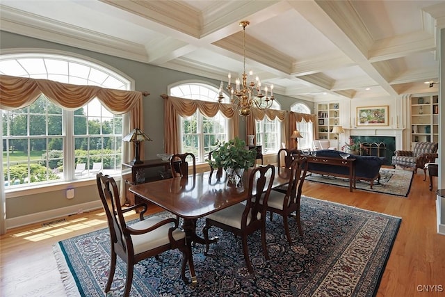 dining room with beamed ceiling, crown molding, coffered ceiling, and a healthy amount of sunlight